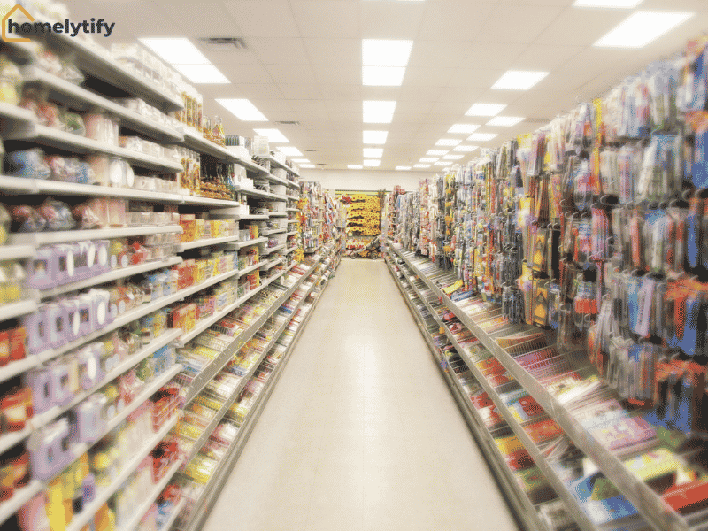 Wide aisle of a dollar store filled with colorful, budget-friendly household and everyday products on shelves