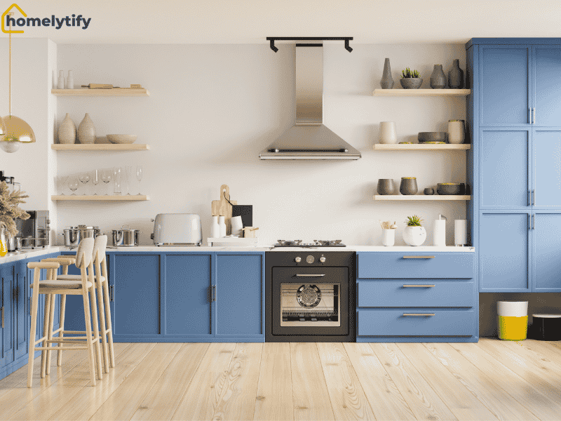 A well-organized rental home kitchen with blue cabinets, open shelves, and maximized counter space for smart storage