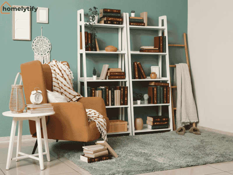 White ladder shelves filled with books and decor beside a cozy armchair in a stylish rental home living room 
