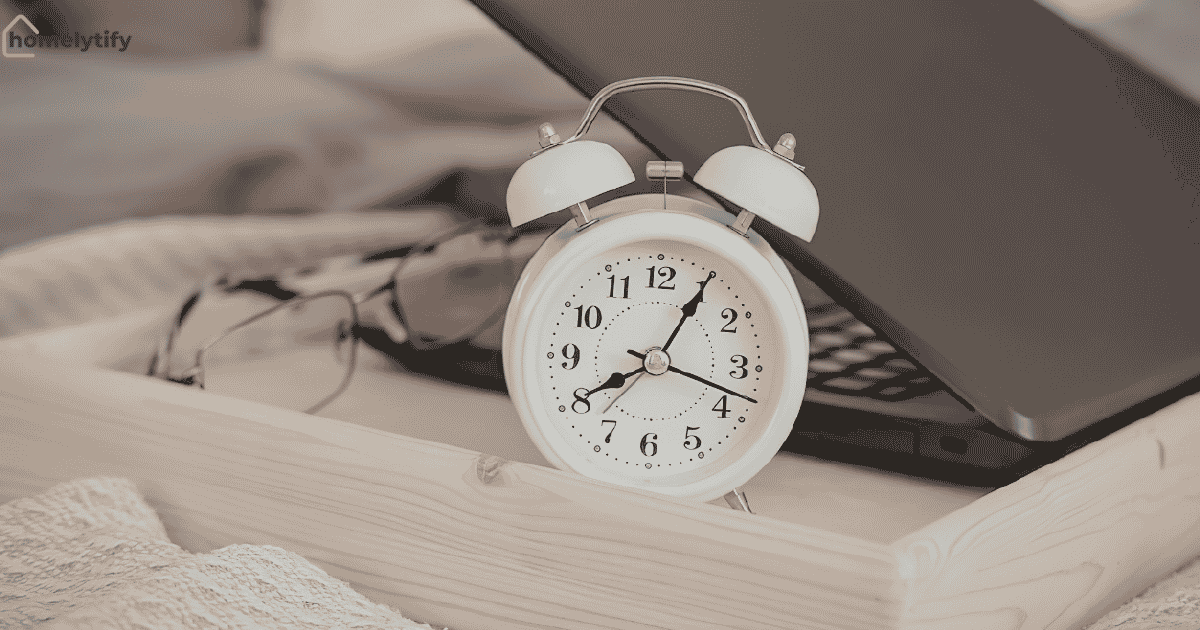 Morning routine ideas with an alarm clock showing 8:40, glasses, and a laptop on a wooden tray in a cozy bedroom setting.