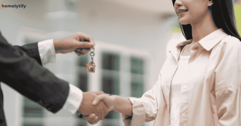 A landlord handing house keys to a smiling tenant with a handshake — a fresh start to organize a rental home