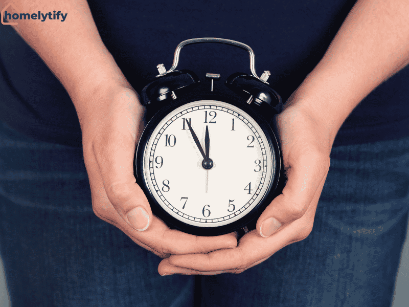 A person holding an alarm clock showing why you should protect your first five minutes of the morning