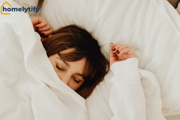Sleep completion for morning routine — woman sleeping peacefully wrapped in white bedding.