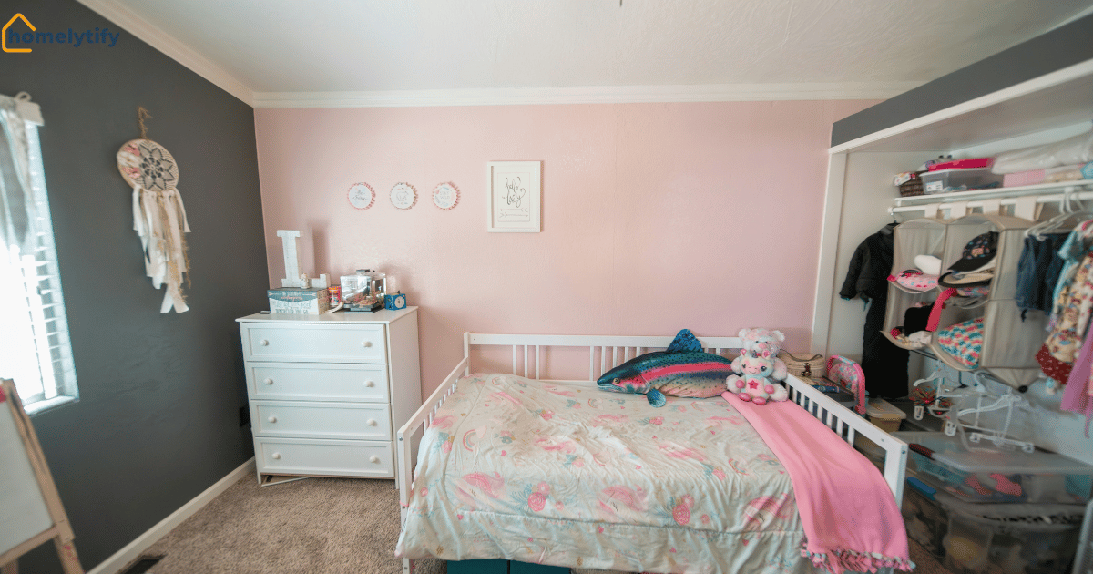 Pink small bedroom with white dresser, floral bed, and open closet displaying small bedroom organization ideas.