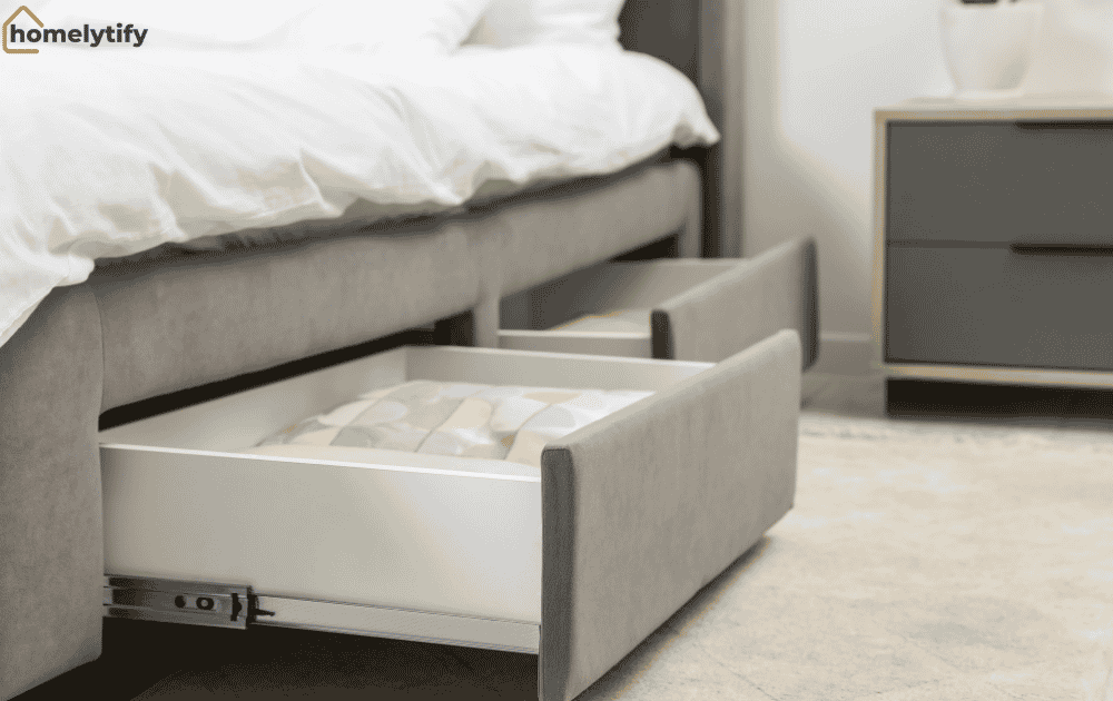 Under-bed space with flat bins and built-in drawers for hidden bedroom storage on a budget.