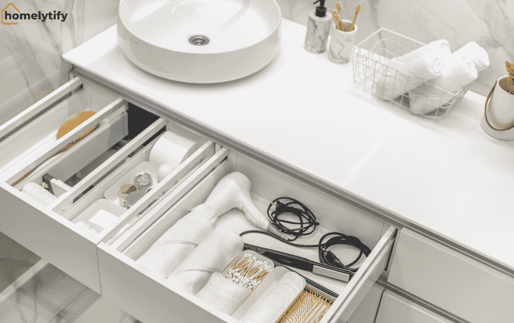 Under sink organizers with divided bathroom drawers storing hair tools, cotton buds, skincare products and folded towels neatly.