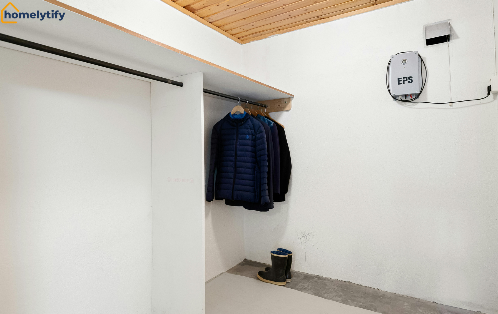 Closet with a bare rod problem — empty hanging rod on the left, jackets and rain boots on the right 