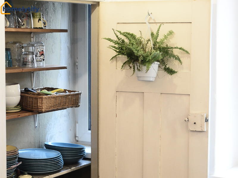 Behind the door storage hack using a hanging plant basket on a pantry door with open shelving