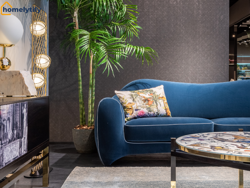 Behind the sofa, a tall indoor palm plant adds a natural touch to a modern blue living room