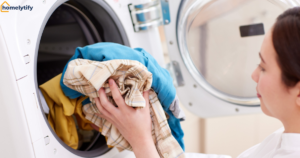 Woman loading clothes to practice frugal laundry habits for small households