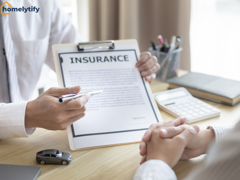 An insurance agent presents a policy document to a client to review and reduce household insurance costs