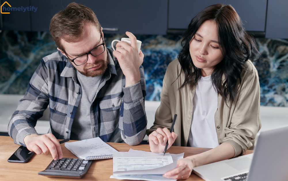 A couple reviewing paperwork and a calculator together to reduce utility bills and manage household costs