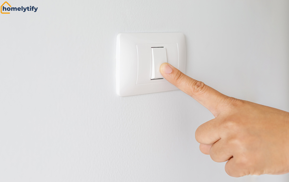 Finger pressing a wall switch to reset a smart bulb by cycling the power on and off five times
