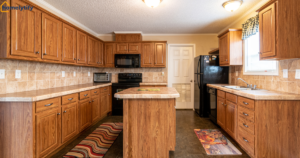 How to organize kitchen cabinets for beginners — wood cabinets, black appliances, and center island in a small kitchen