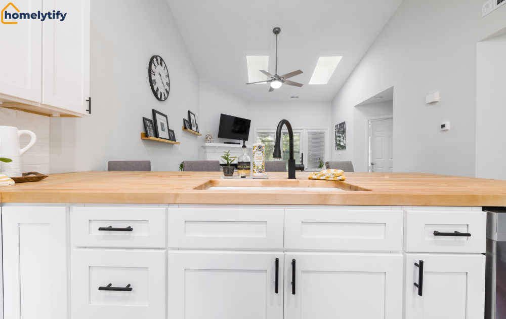White kitchen island sink with a labeled dish soap bottle, showing how to keep cleaning supplies safe under the counter