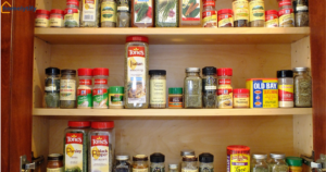 Budget-friendly pantry organization ideas on a budget showing spice jars neatly arranged by size on wooden cabinet shelves