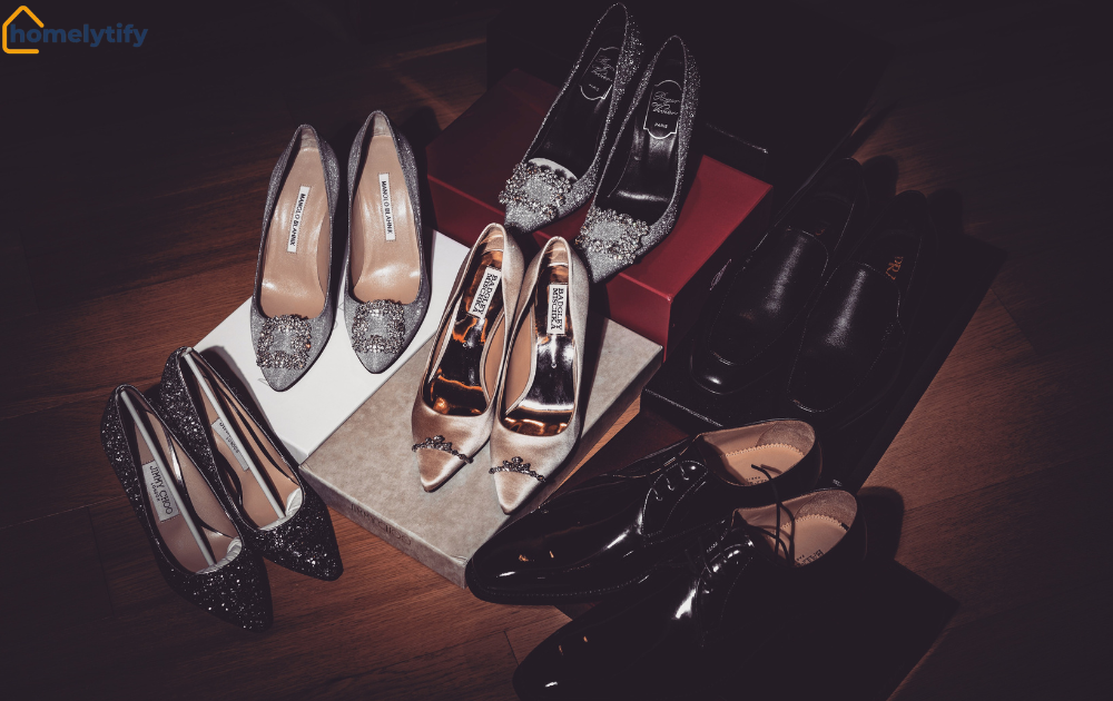 Shoe pile featuring embellished heels, satin pumps, and polished dress shoes displayed together on wooden floor