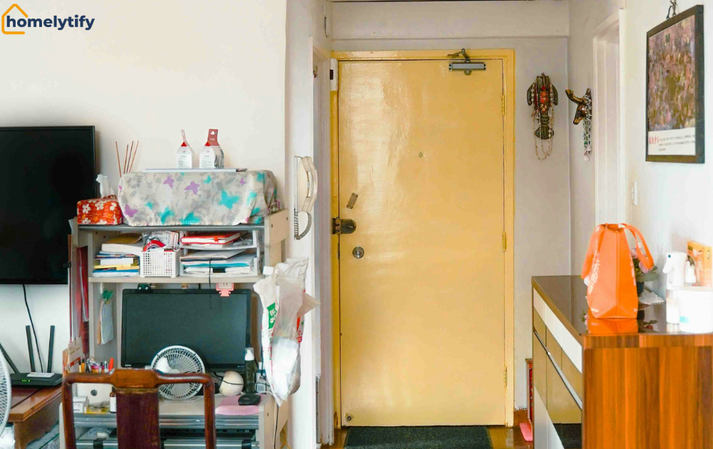 Small entryways get cluttered so fast, as shown by this hallway with overflowing shelves, wooden cabinet, and door mat