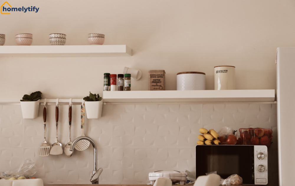 Claiming walls with vertical kitchen storage using floating shelves and a hanging utensil rail